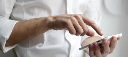 Man typing estimate on phone.